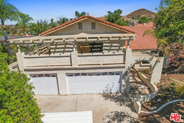 view of front of property featuring a garage and a balcony