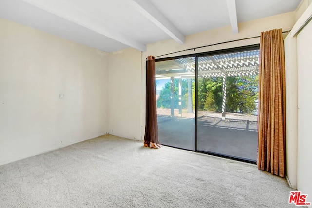 carpeted spare room with beamed ceiling