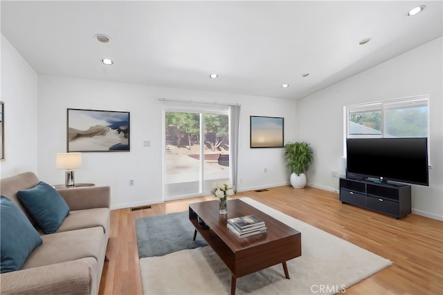 living room featuring light hardwood / wood-style flooring and lofted ceiling