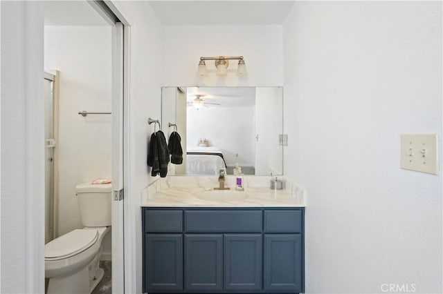 bathroom with vanity, toilet, and ceiling fan