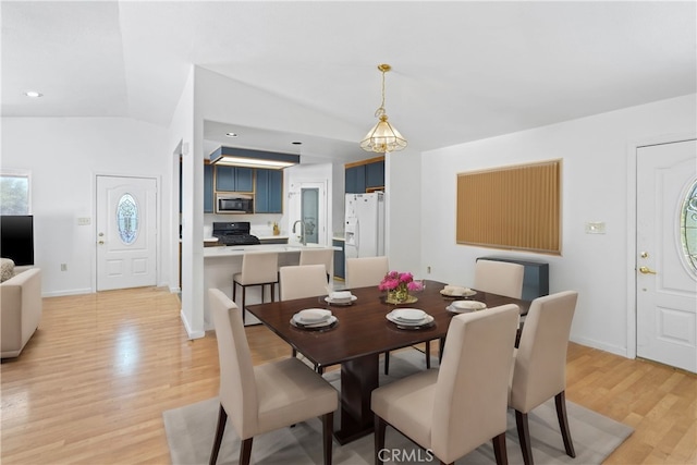 dining space featuring light hardwood / wood-style floors and vaulted ceiling