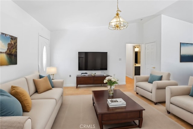 living room featuring an inviting chandelier and light hardwood / wood-style flooring