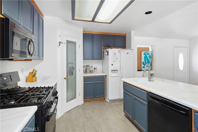 kitchen with blue cabinetry, light hardwood / wood-style flooring, sink, and black appliances