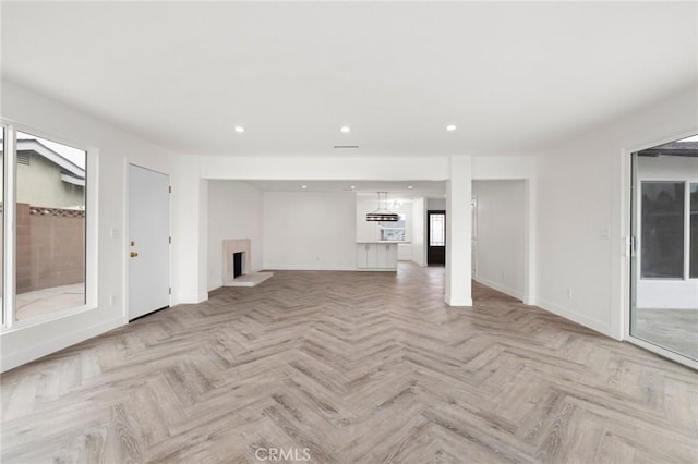 unfurnished living room featuring light parquet flooring