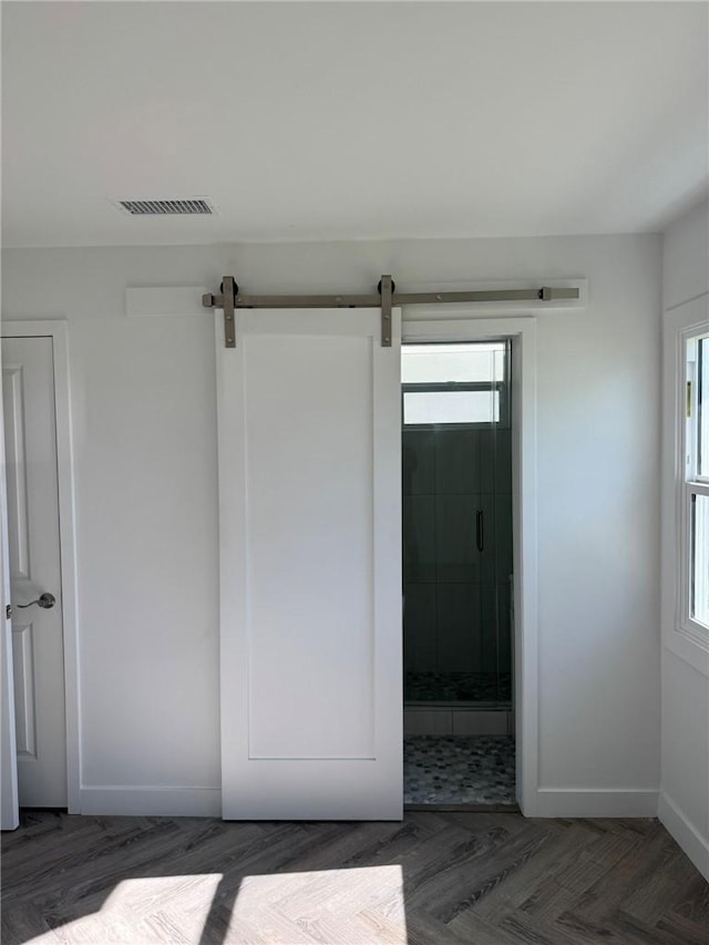 interior space featuring a barn door and connected bathroom