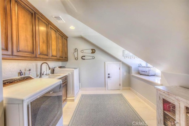 washroom featuring cabinets, separate washer and dryer, and light tile patterned floors