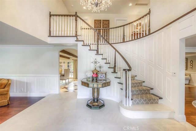 staircase with tile patterned flooring and a notable chandelier