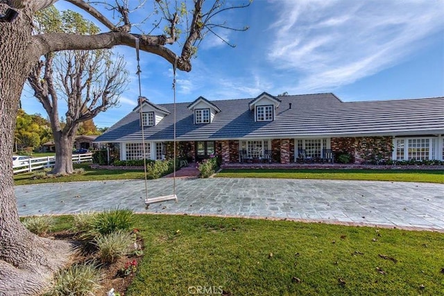 cape cod house with a front yard