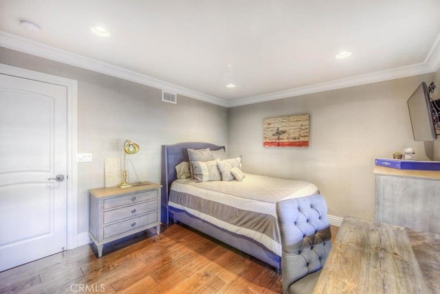 bedroom with crown molding and hardwood / wood-style flooring