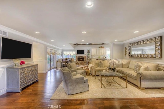 living room with crown molding and hardwood / wood-style floors