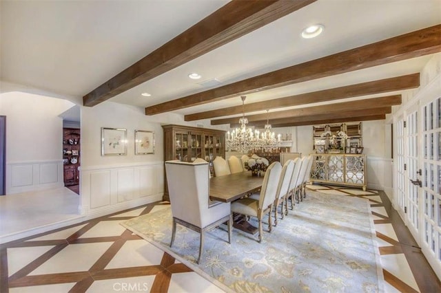 dining space with an inviting chandelier and beam ceiling