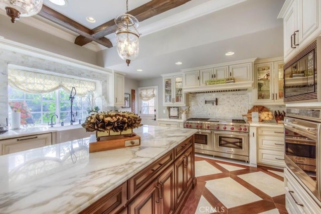 kitchen featuring stainless steel appliances, decorative light fixtures, decorative backsplash, light stone countertops, and beam ceiling