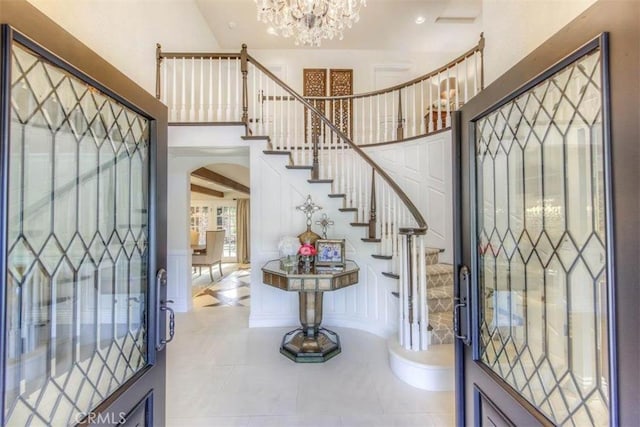 tiled entryway with a chandelier