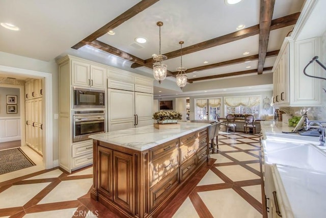 kitchen featuring light stone countertops, a center island, hanging light fixtures, oven, and black microwave