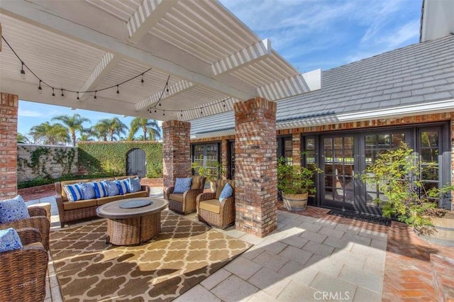 view of patio with french doors, an outdoor living space with a fire pit, and a pergola