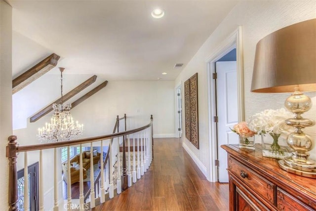 corridor with a notable chandelier and dark hardwood / wood-style floors