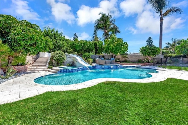 view of swimming pool featuring a patio, pool water feature, a yard, and an in ground hot tub