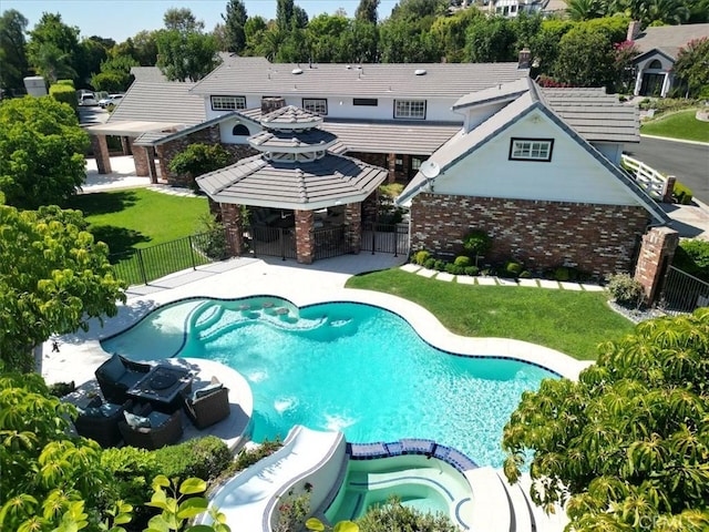 view of swimming pool featuring a yard and an in ground hot tub