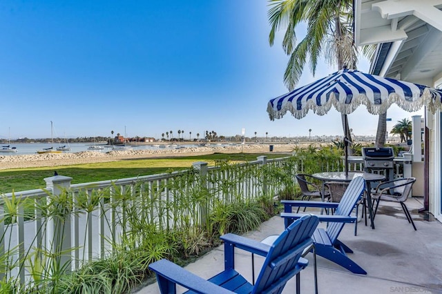 balcony with area for grilling and a water view