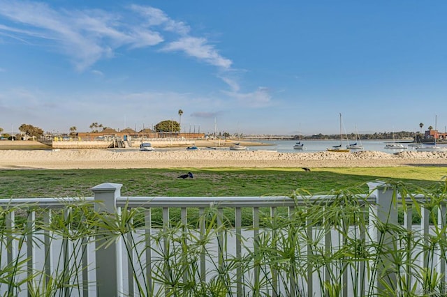 view of yard with a water view and a beach view