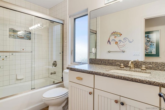 full bathroom featuring vanity, toilet, and bath / shower combo with glass door