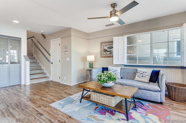 living room with light hardwood / wood-style floors and ceiling fan