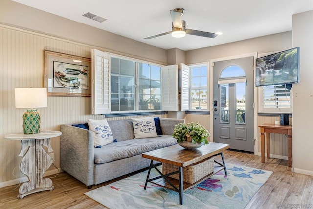 living room featuring ceiling fan, light hardwood / wood-style flooring, and a healthy amount of sunlight