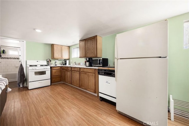 kitchen featuring backsplash, light hardwood / wood-style flooring, and white appliances