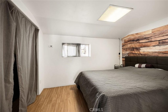 bedroom featuring light hardwood / wood-style flooring and lofted ceiling