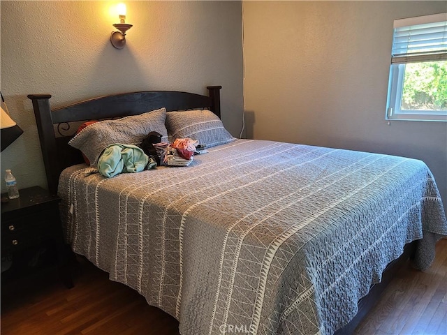 bedroom with dark hardwood / wood-style floors