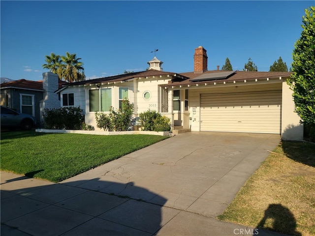 single story home with a front lawn, a garage, and solar panels