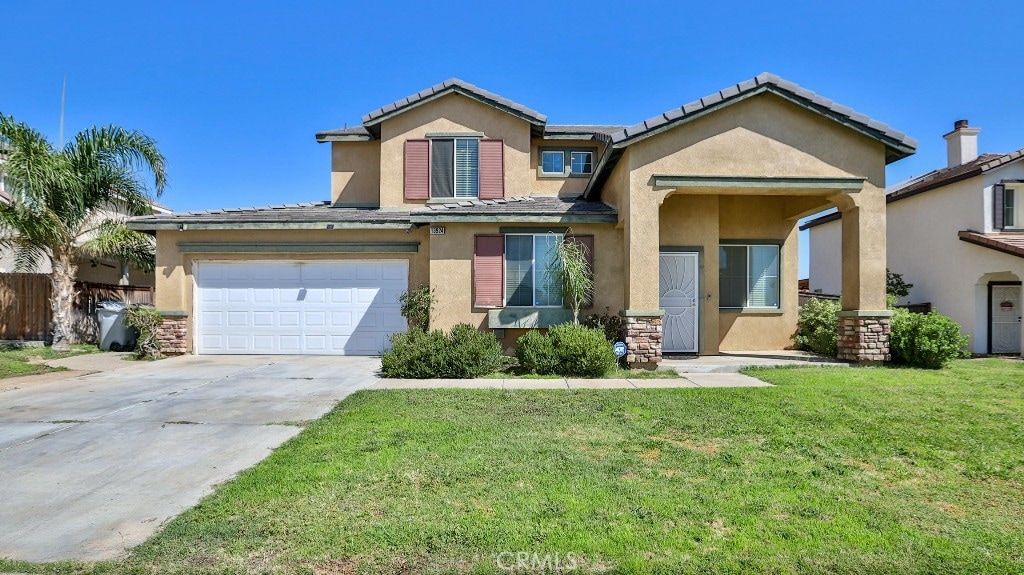 view of front facade featuring stucco siding, driveway, and a front lawn