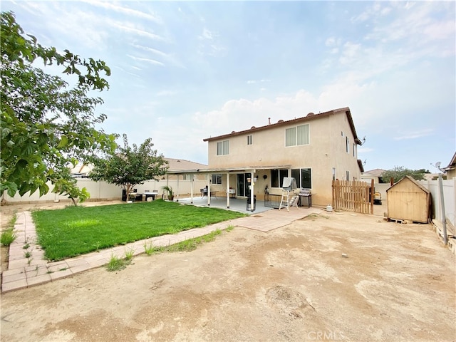 back of property with a lawn and a patio area