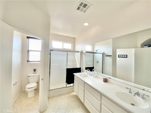 bathroom featuring vanity, a shower with shower door, toilet, and a textured ceiling