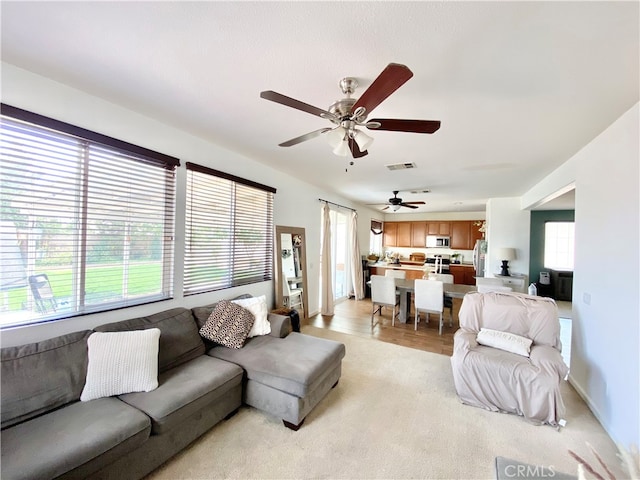 living room with ceiling fan and light hardwood / wood-style flooring