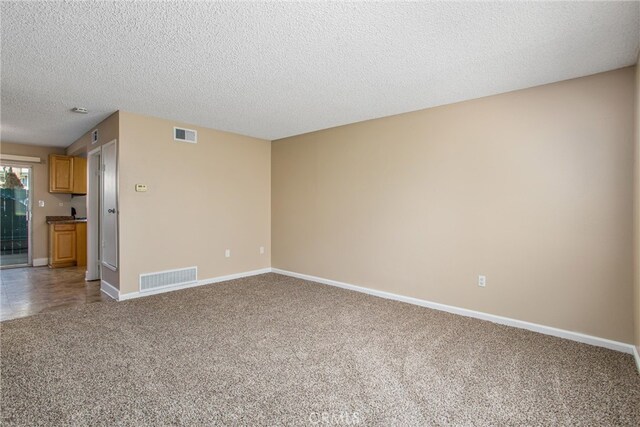 unfurnished living room featuring a textured ceiling and carpet floors