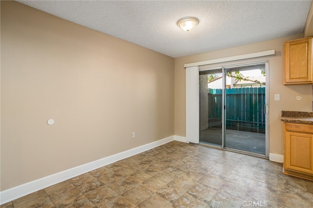 unfurnished room with a textured ceiling