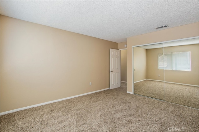 unfurnished bedroom featuring carpet, a closet, and a textured ceiling