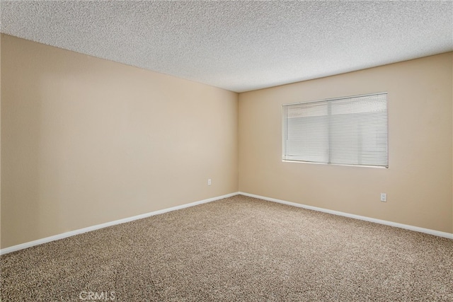 spare room with a textured ceiling and carpet flooring