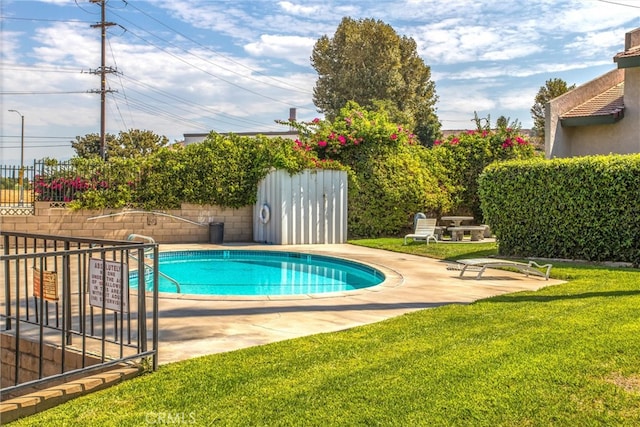 view of swimming pool with a patio and a yard