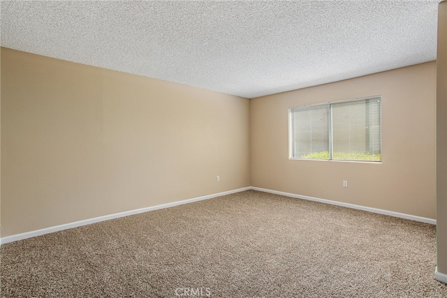 carpeted empty room with a textured ceiling