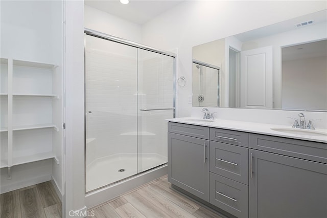 bathroom featuring an enclosed shower, vanity, and hardwood / wood-style flooring