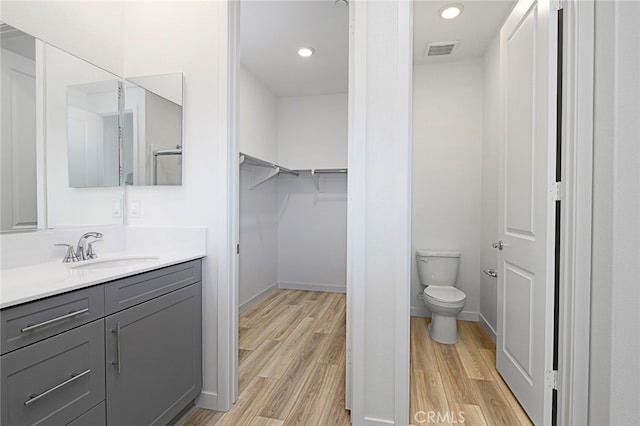 bathroom featuring vanity, toilet, and hardwood / wood-style flooring