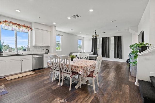 dining room featuring an inviting chandelier, sink, and dark hardwood / wood-style flooring