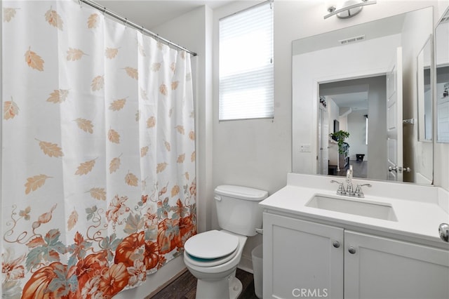 bathroom with a shower with shower curtain, hardwood / wood-style floors, vanity, and toilet