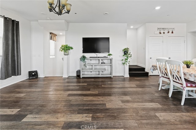 living room featuring an inviting chandelier and dark hardwood / wood-style flooring