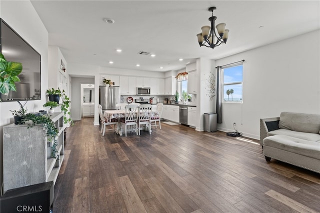 living room featuring a notable chandelier and dark wood-type flooring