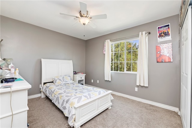 carpeted bedroom with ceiling fan and a closet