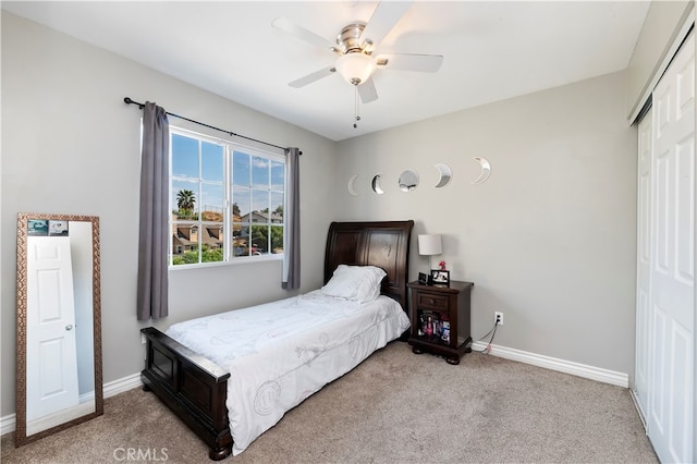 bedroom with light carpet, ceiling fan, and a closet