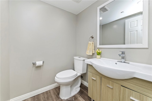 bathroom featuring wood-type flooring, vanity, and toilet